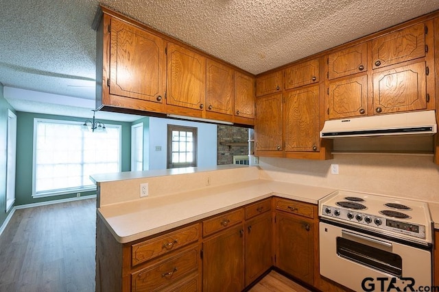 kitchen with a textured ceiling, ventilation hood, brown cabinetry, and white electric range oven