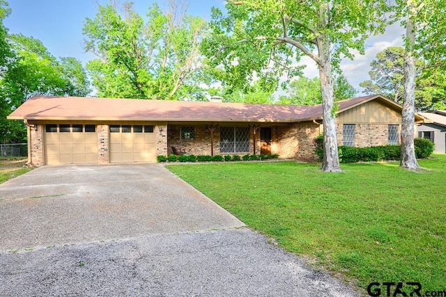 ranch-style house featuring driveway, a front yard, an attached garage, and brick siding