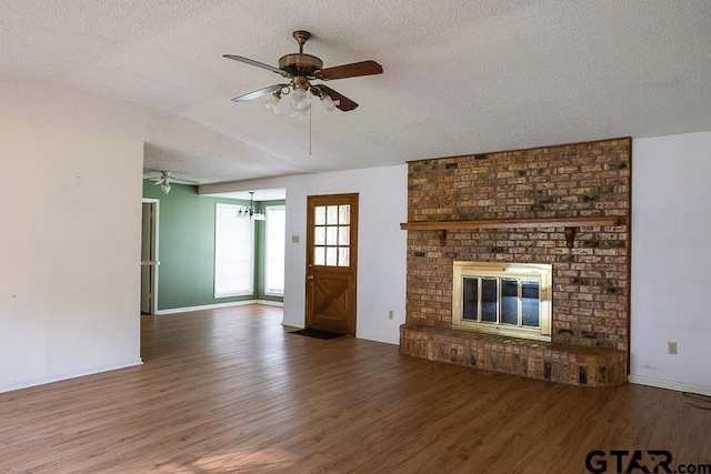 unfurnished living room featuring a textured ceiling, a ceiling fan, wood finished floors, and baseboards