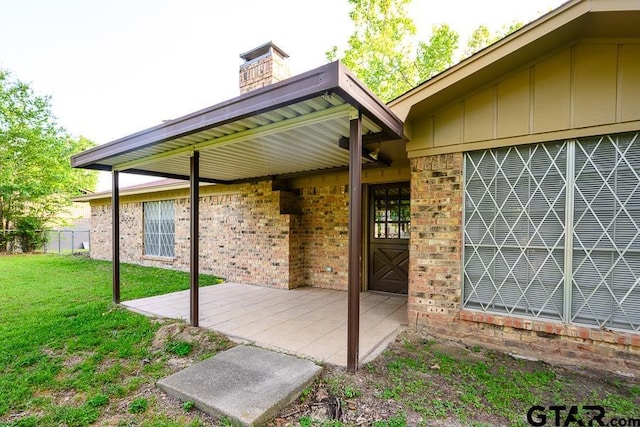exterior space featuring a patio, a yard, board and batten siding, brick siding, and fence