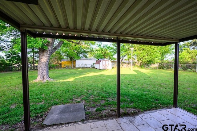 view of yard featuring an outdoor structure, a storage shed, a fenced backyard, and a patio area
