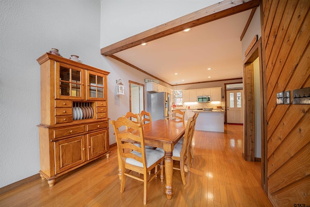 dining space featuring ornamental molding and light hardwood / wood-style floors