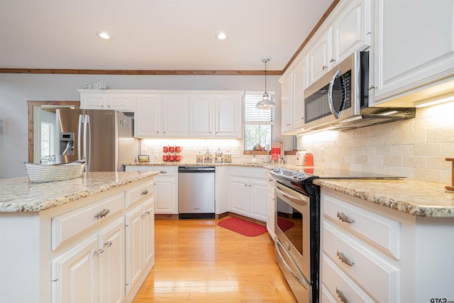 kitchen with light hardwood / wood-style floors, white cabinets, crown molding, pendant lighting, and appliances with stainless steel finishes