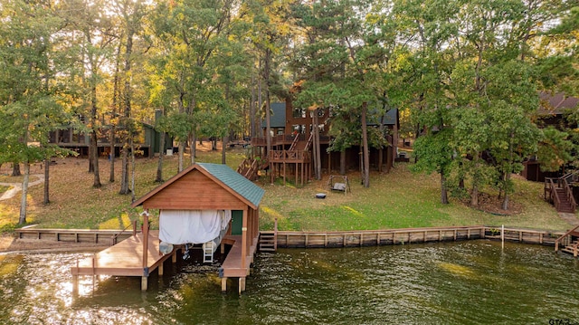 view of dock with a yard and a water view