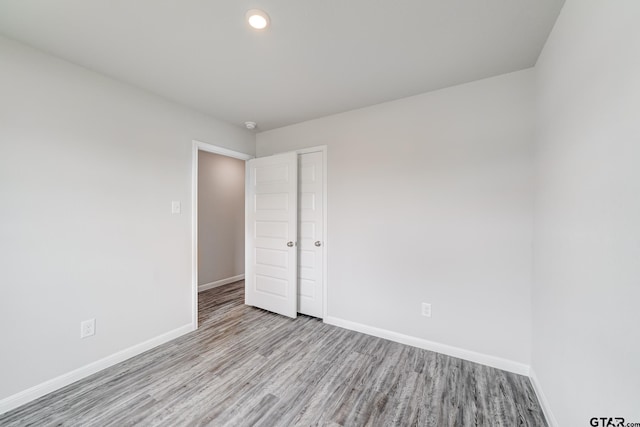 205 Highland Forest Dr, Gilmer, TX 75644 - unfurnished bedroom with wood finished floors, baseboards, recessed lighting, and a closet