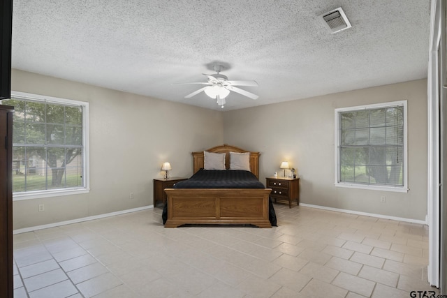 bedroom featuring ceiling fan and a textured ceiling