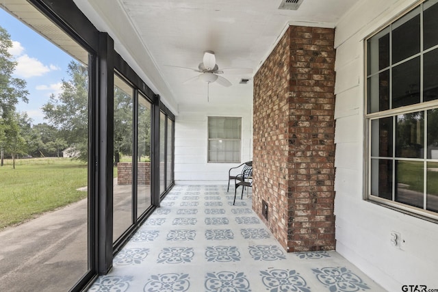 unfurnished sunroom with ceiling fan