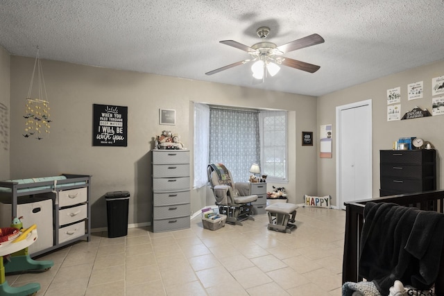 tiled bedroom featuring ceiling fan and a textured ceiling