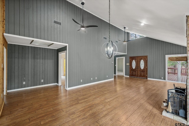 381 Winding Trl, Holly Lake Ranch, TX 75765 - unfurnished living room featuring wood-type flooring, healthy amount of natural light, a chandelier, high vaulted ceiling, and wood walls