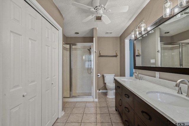 381 Winding Trl, Holly Lake Ranch, TX 75765 - full bathroom with a closet, toilet, a stall shower, double vanity, and a textured ceiling