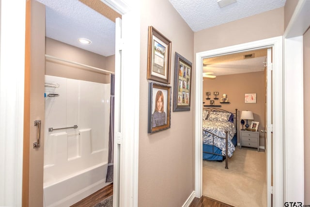 bathroom featuring baseboards, connected bathroom, visible vents, and a textured ceiling