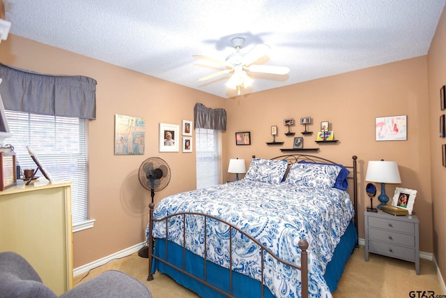 carpeted bedroom with multiple windows, baseboards, and a textured ceiling