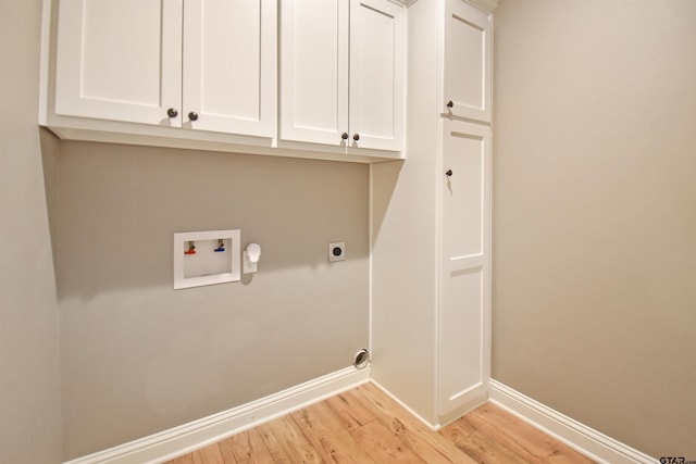 clothes washing area featuring cabinets, electric dryer hookup, washer hookup, and light wood-type flooring