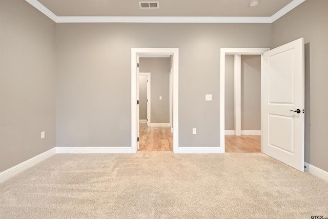 unfurnished bedroom featuring crown molding and light carpet