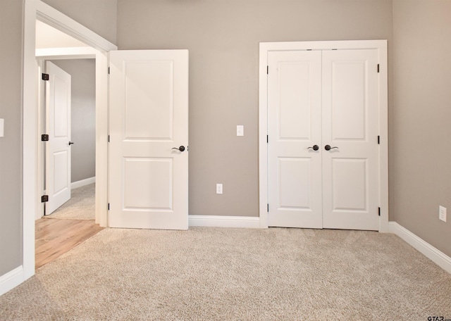 unfurnished bedroom featuring light colored carpet and a closet