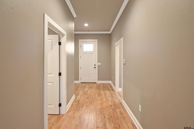 doorway with crown molding and light hardwood / wood-style flooring