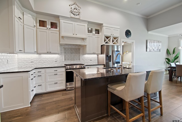 2946 Guinn Farms Rd, Tyler, TX 75707 - kitchen with stainless steel appliances, a kitchen breakfast bar, crown molding, decorative backsplash, and a kitchen island with sink