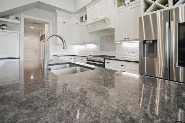 2946 Guinn Farms Rd, Tyler, TX 75707 - kitchen with stainless steel appliances, white cabinetry, dark stone countertops, decorative backsplash, and glass insert cabinets