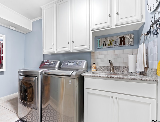 laundry area featuring ornamental molding, separate washer and dryer, light tile patterned floors, cabinets, and sink