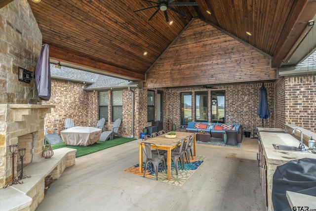 view of patio / terrace with grilling area, an outdoor living space with a fireplace, ceiling fan, and a sink