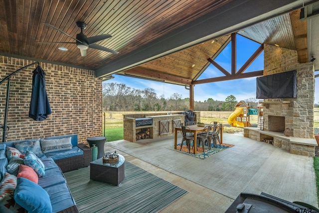 view of patio with outdoor dining space, area for grilling, an outdoor living space with a fireplace, and a ceiling fan