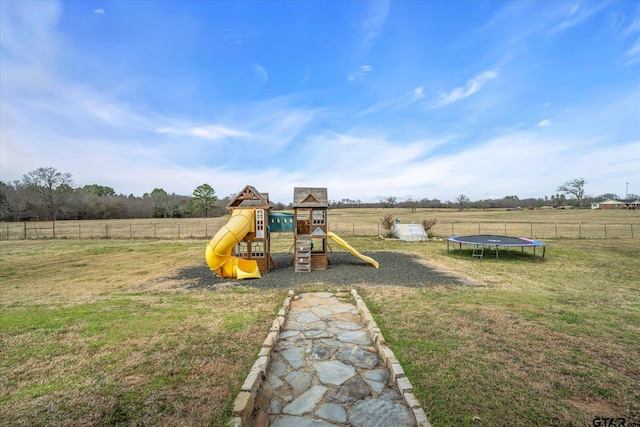 view of playground with a trampoline, a lawn, and a rural view