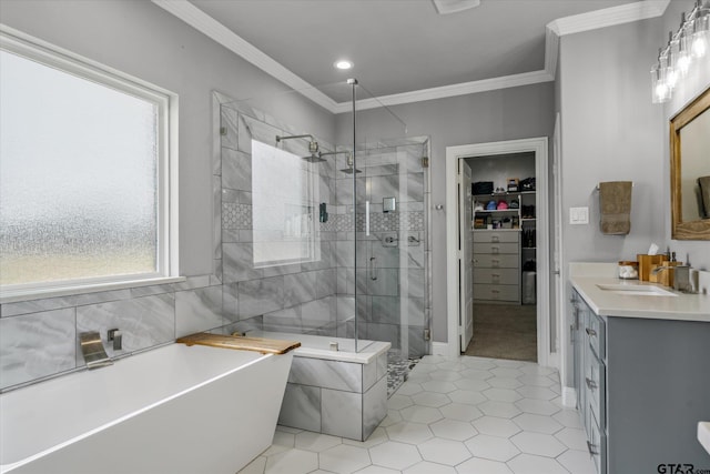 bathroom featuring a walk in closet, a stall shower, crown molding, a freestanding bath, and vanity