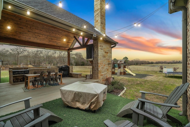 view of patio with outdoor dining space, a trampoline, fence, a playground, and a grill