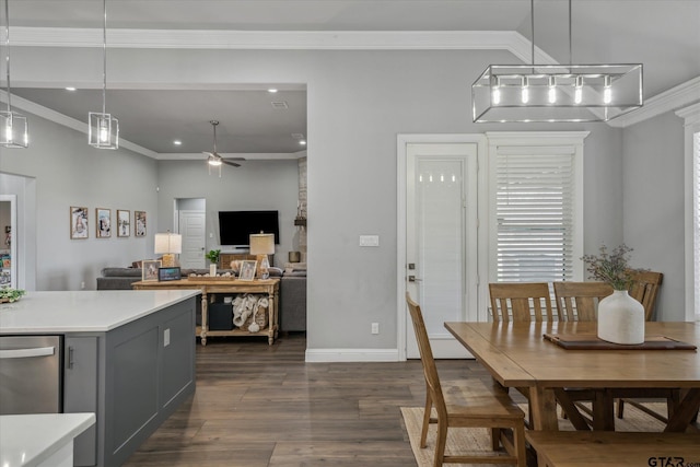 dining space featuring crown molding, dark wood-style floors, baseboards, and ceiling fan