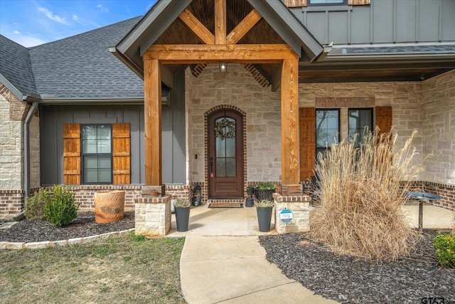 property entrance with brick siding, board and batten siding, a shingled roof, a porch, and stone siding