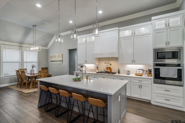 kitchen featuring backsplash, crown molding, premium range hood, stainless steel appliances, and dark wood-style flooring