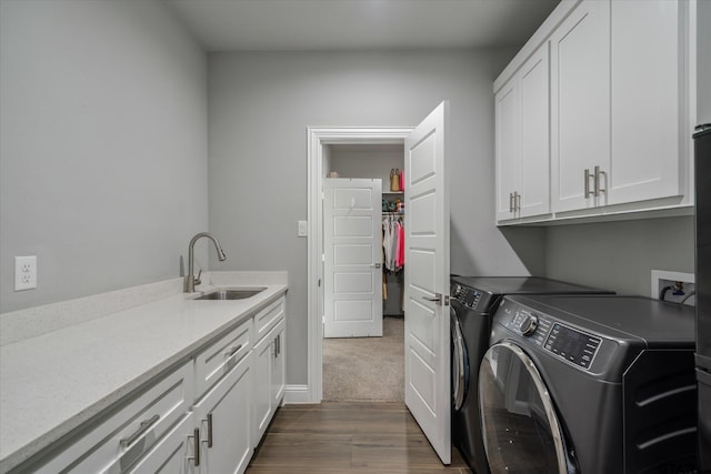 laundry area with a sink, dark wood-type flooring, cabinet space, and washer and clothes dryer