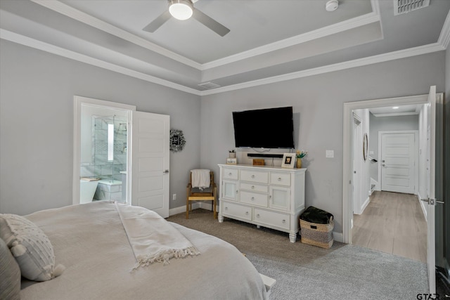 carpeted bedroom with visible vents, a raised ceiling, baseboards, and ornamental molding