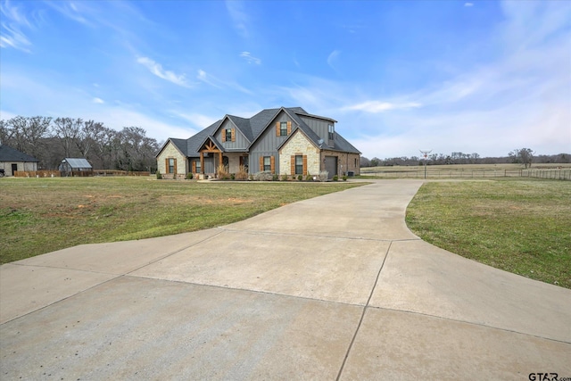 view of front of home featuring stone siding, board and batten siding, and a front lawn