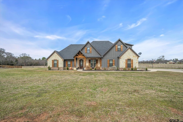 view of front of house with roof with shingles, board and batten siding, and a front yard