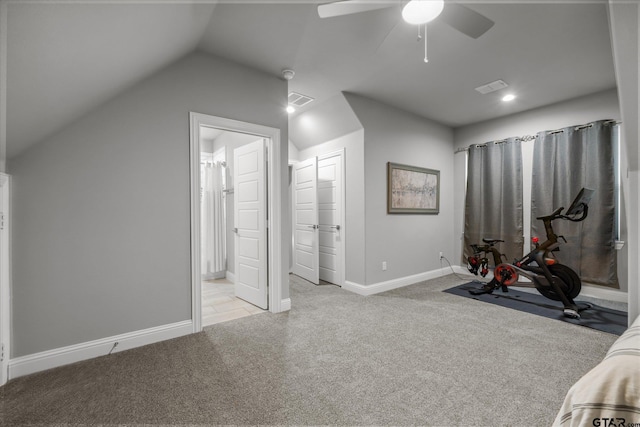 exercise room featuring light carpet, visible vents, baseboards, and lofted ceiling