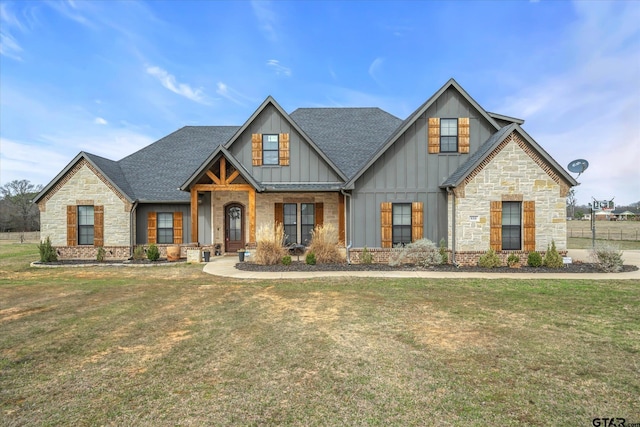 view of front of property with a front yard, board and batten siding, and a shingled roof