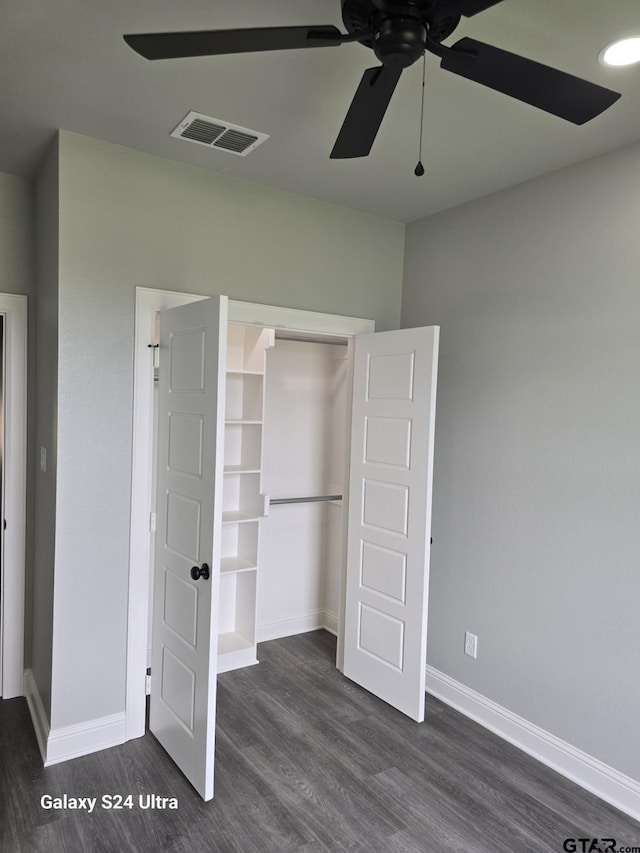 unfurnished bedroom with a ceiling fan, dark wood-style flooring, visible vents, baseboards, and a closet