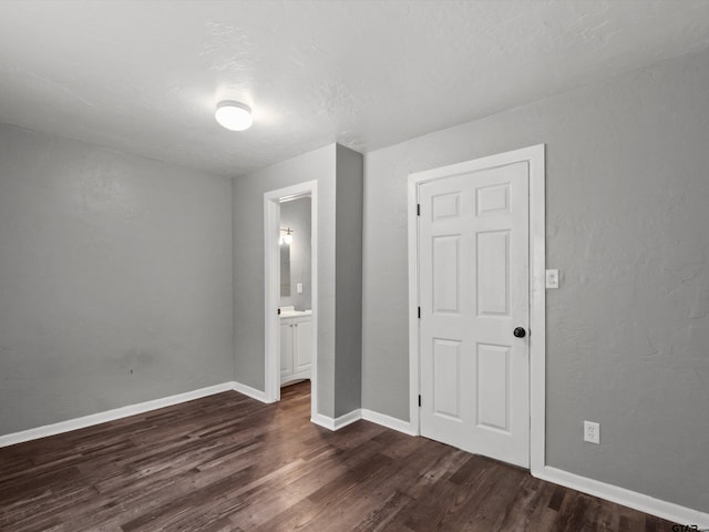 509 Clark St, Gilmer, TX 75644 - unfurnished bedroom with dark wood-style flooring and ensuite bath