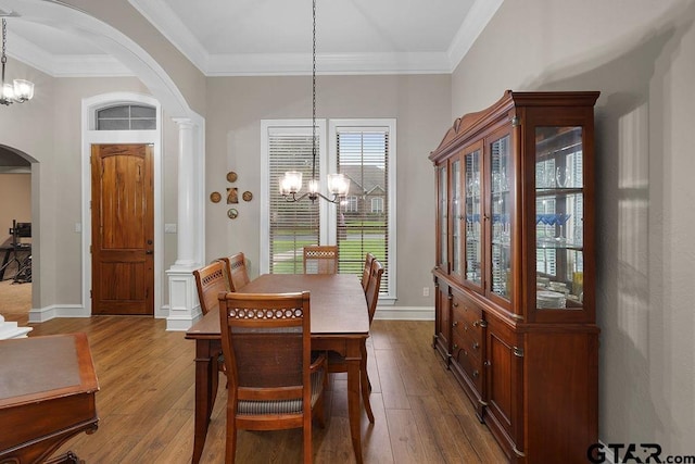 2322 Kingsmill Cir, Tyler, TX 75703 - dining space featuring a chandelier, arched walkways, dark wood-style floors, and crown molding