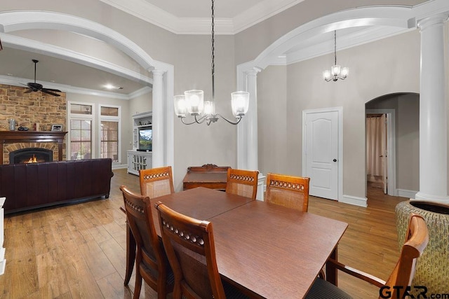 2322 Kingsmill Cir, Tyler, TX 75703 - dining space with a chandelier, a ceiling fan, light wood finished floors, a fireplace, and ornamental molding