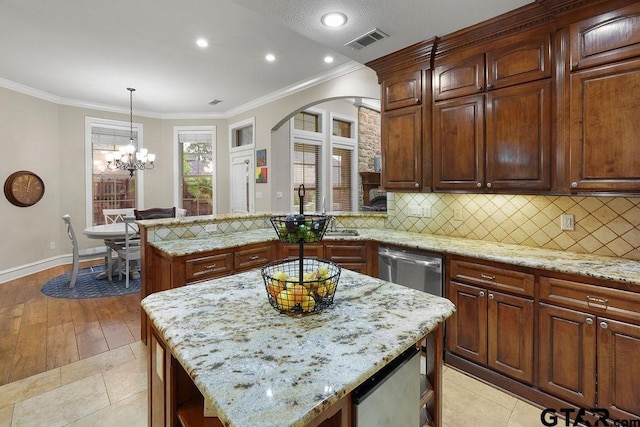2322 Kingsmill Cir, Tyler, TX 75703 - kitchen with a peninsula, decorative backsplash, light stone counters, arched walkways, and ornamental molding