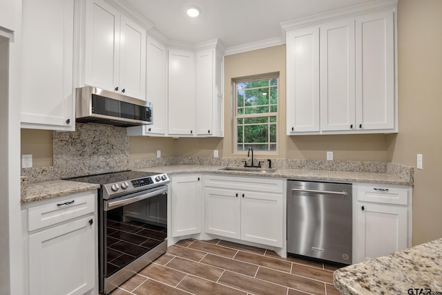 1720 Outer Dr, Tyler, TX 75701 - kitchen with appliances with stainless steel finishes, white cabinets, recessed lighting, light stone countertops, and ornamental molding