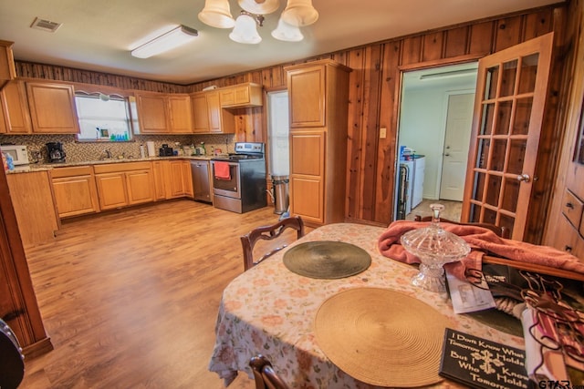 17215 Tartlon Rd, Mabank, TX 75147 - kitchen with appliances with stainless steel finishes, washer and dryer, a chandelier, backsplash, and light wood-type flooring