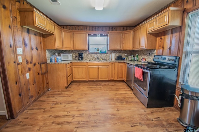 17215 Tartlon Rd, Mabank, TX 75147 - kitchen featuring appliances with stainless steel finishes, light wood-type flooring, tasteful backsplash, and light stone countertops