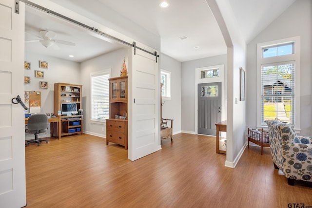 office featuring a wealth of natural light, wood-type flooring, and ceiling fan