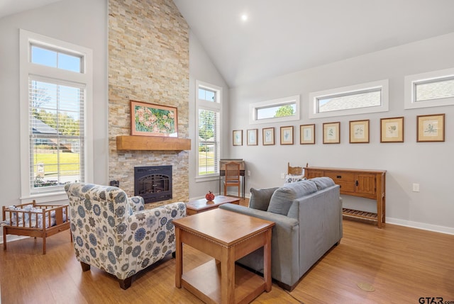 living room with high vaulted ceiling, light wood-type flooring, and a fireplace