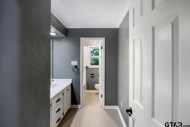 1216 Kingspark Dr, Tyler, TX 75703 - bathroom featuring toilet, vanity, crown molding, tile patterned flooring, and a textured wall
