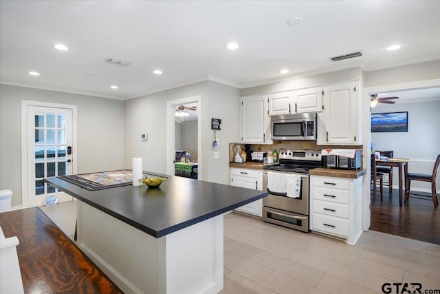 1216 Kingspark Dr, Tyler, TX 75703 - kitchen with a ceiling fan, dark countertops, stainless steel appliances, and crown molding