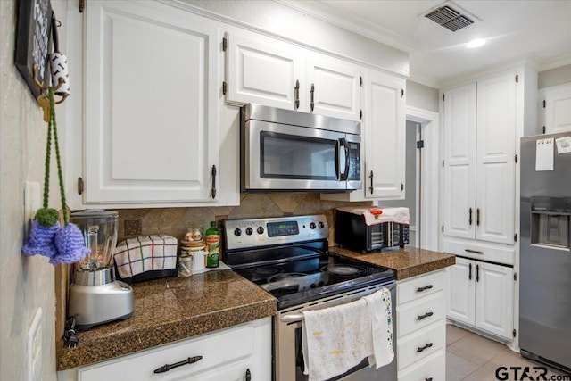1216 Kingspark Dr, Tyler, TX 75703 - kitchen with white cabinetry, ornamental molding, stainless steel appliances, and decorative backsplash